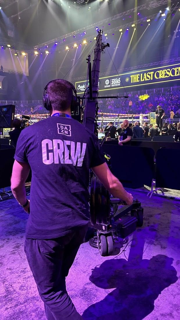 DAZN, Riyadh Season boxing in Riyadh: a crew member carrying camera gear across the arena floor before a fight